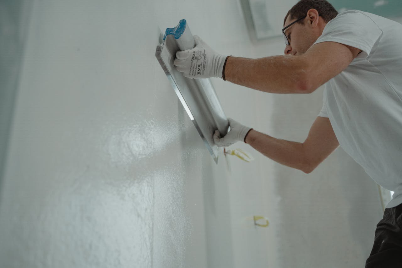 The Art of Drawing Readers In: Your attractive post title goes here A man works on home renovation, applying plaster to an interior wall for a smooth finish.