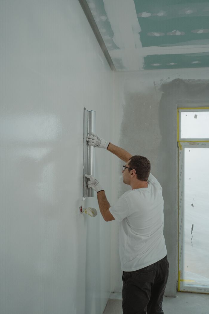 Mastering the First Impression: Your intriguing post title goes here Adult male painting interior walls white in a house renovation project.